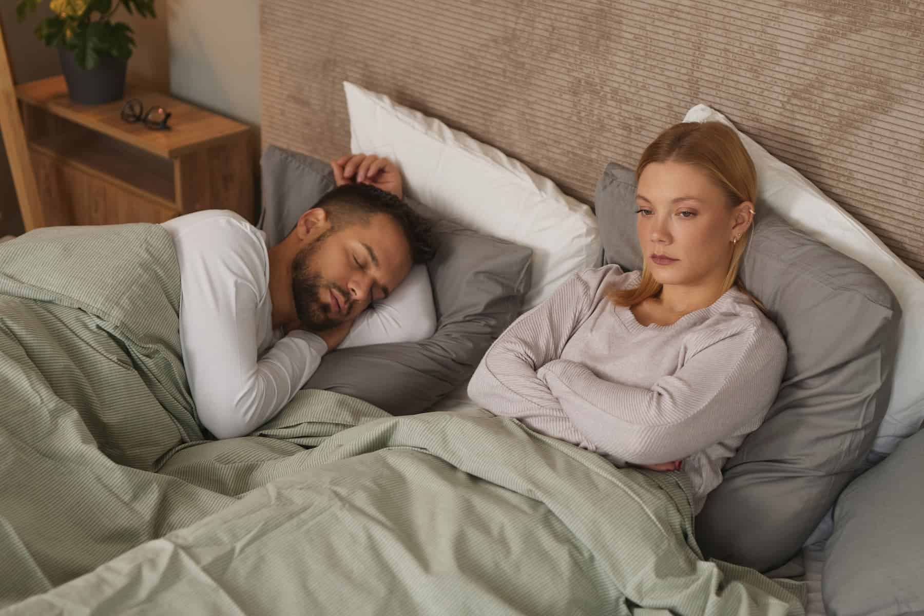 A woman is struggling to fall asleep because she went to bed angry and upset with her partner, neglecting the importance of resolving conflicts for a better night's rest.