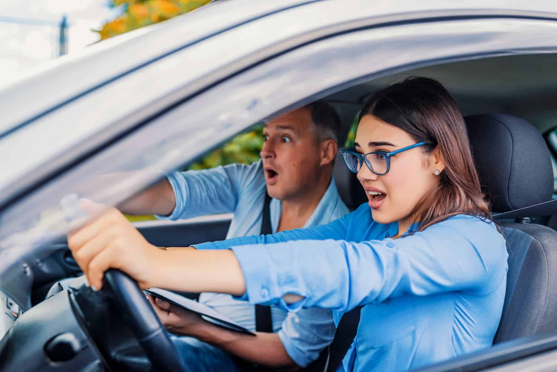 A young female driver lacks confidence while driving with her instructor.