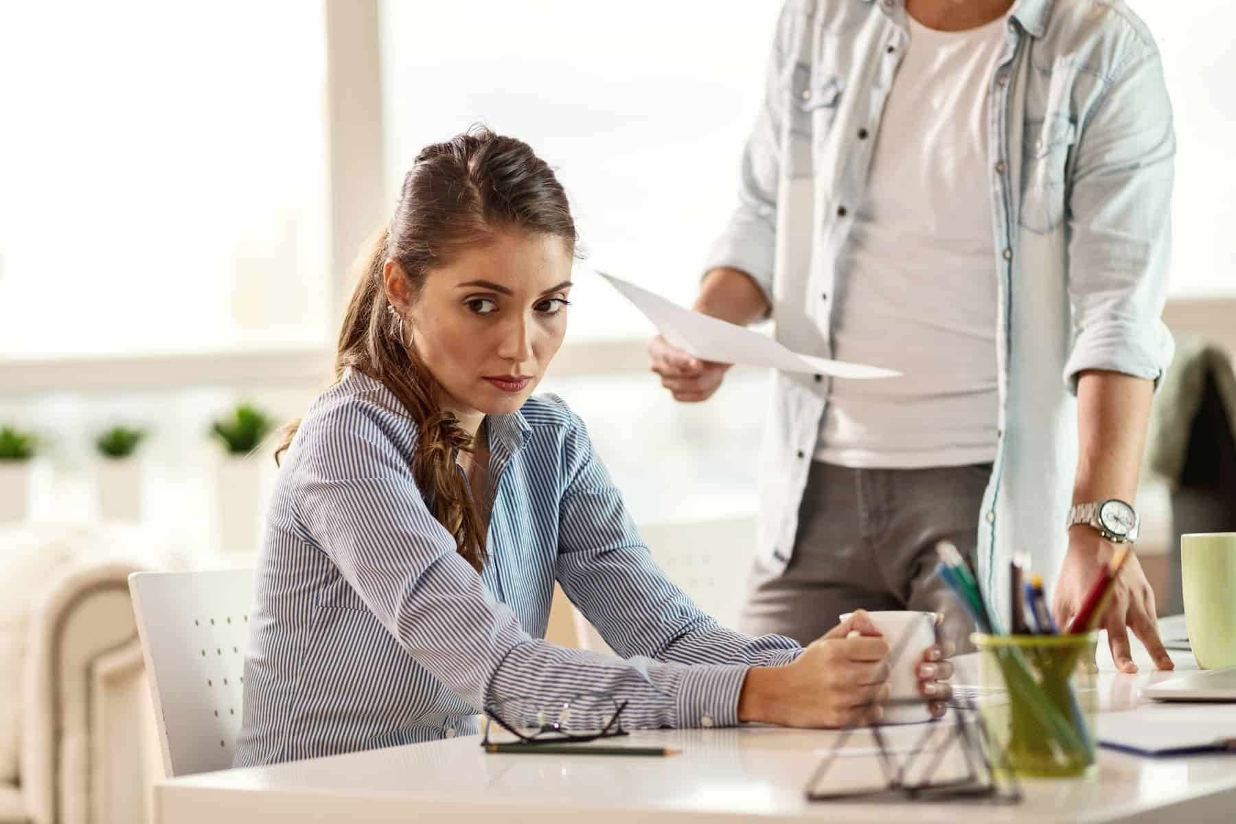 In the office, a sad businesswoman receives criticism from her boss.