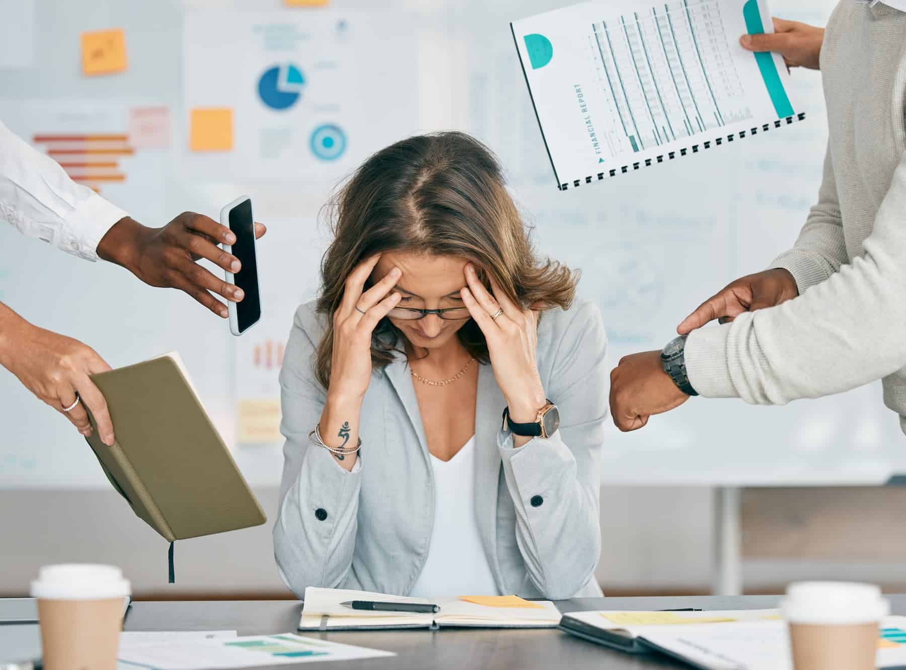 Woman struggling to find balance between work and life. She is overworked and overwhelmed with deadlines and suffers from burnout.