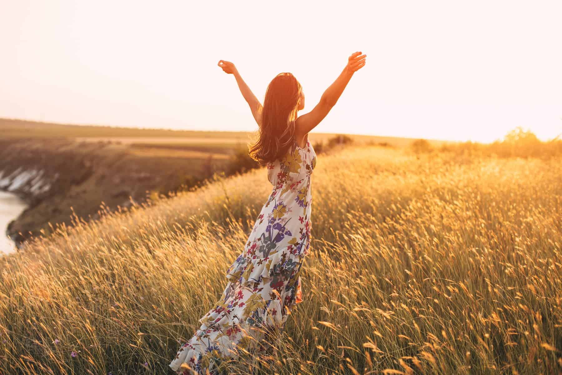 A woman enjoys a summer day in nature, feeling free and joyful as she appreciates the benefits of being a Highly Sensitive Person.