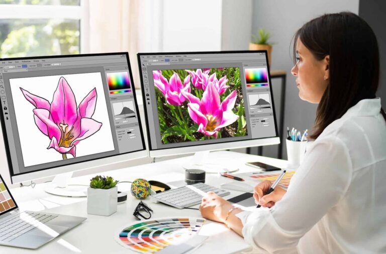 Graphic Designer Artist working on multiple computer screens. This is one of the best jobs for highly sensitive people.