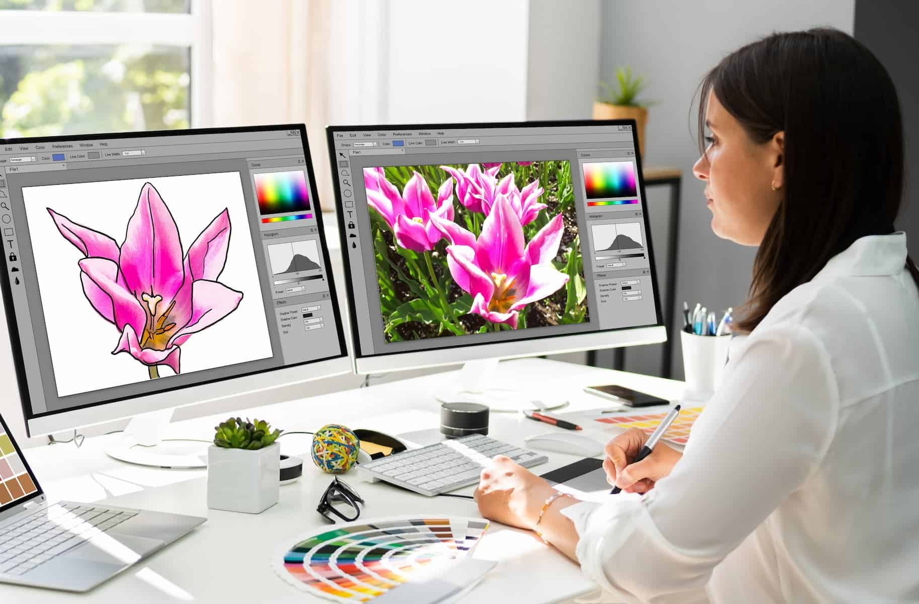 Graphic Designer Artist working on multiple computer screens. This is one of the best jobs for highly sensitive people.