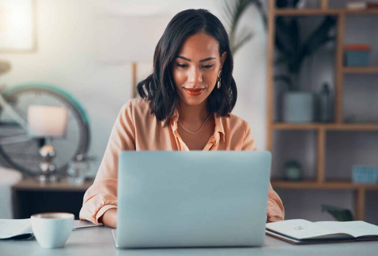 Shot of a woman using her laptop while setting S.M.A.R.T. goals to make sure she achieves success.