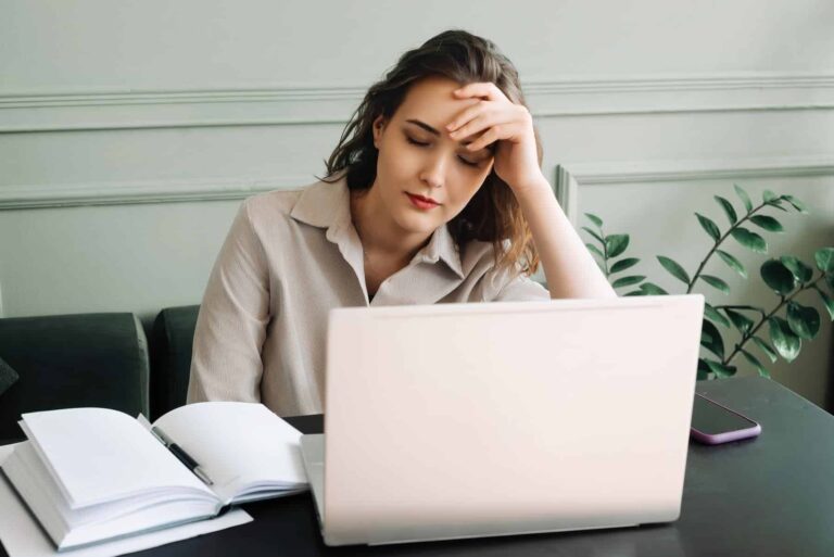 At her office desk, a young woman finds it hard to keep up with work, quietly questioning why life feels so overwhelming.