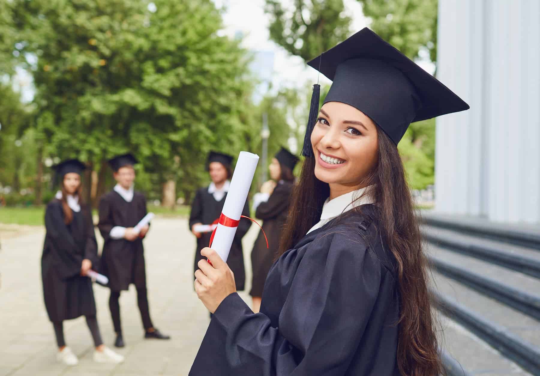 A young female graduate standing proudly among her peers, at the top of her class, exemplifies the journey from failure to success.