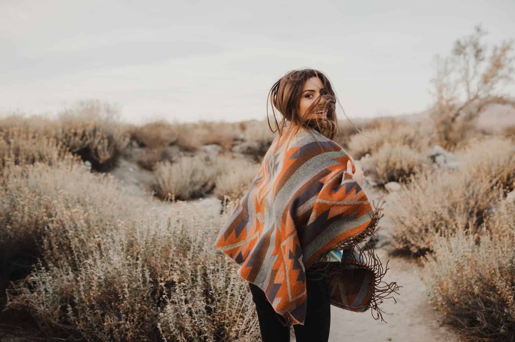 A hipster girl is enjoying the desert, embracing the experience with her empathic nature.