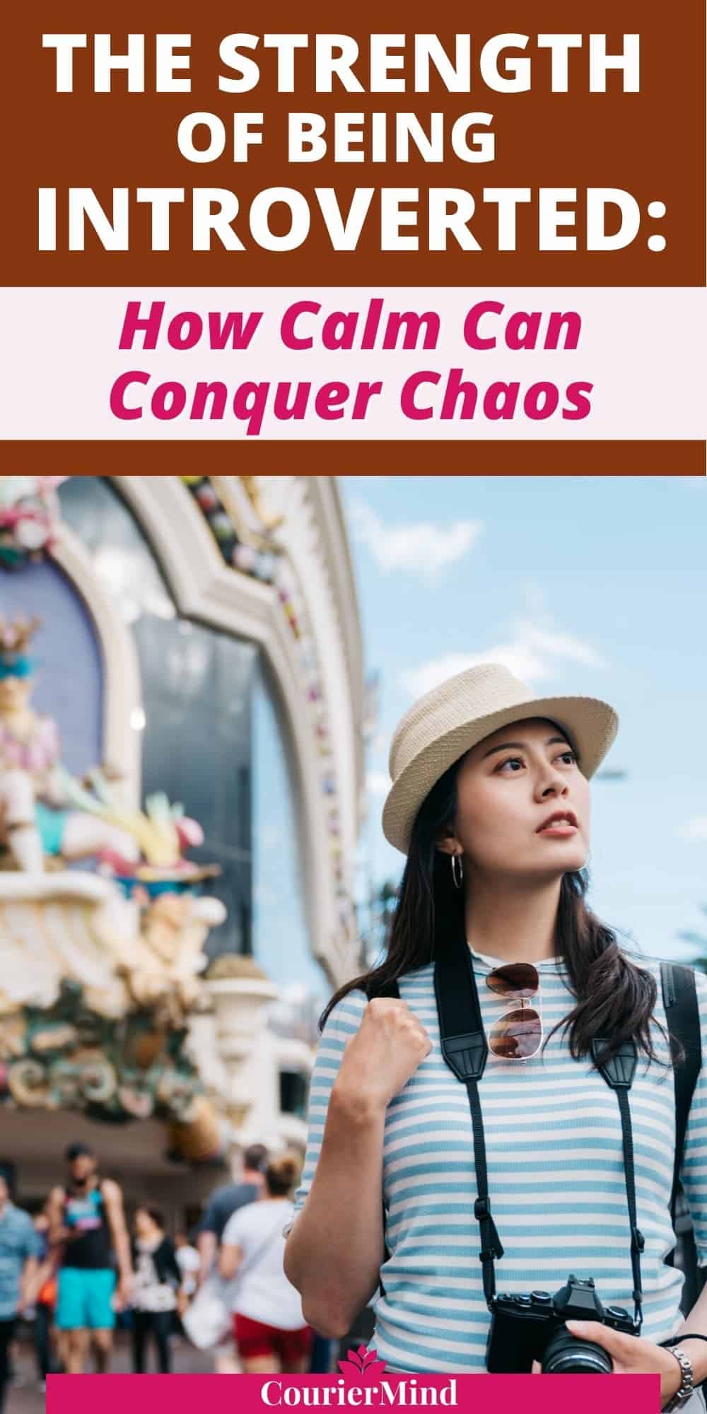 A woman wearing a hat and holding a camera looks up at a building, capturing the thoughtful, observant qualities of being introverted.