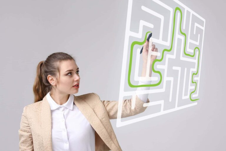 A woman interacting with a digital maze projected in front of her, tracing a green path with a stylus showcasing a growth mindset brain.