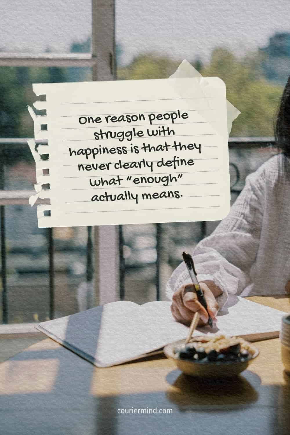 Woman writing in a notebook at a table with a bowl of snacks and a cup nearby, with trees visible through the window.