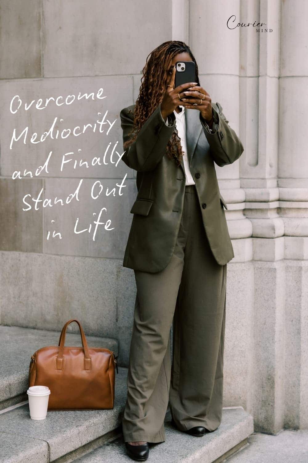 Woman in a green suit holding a smartphone while standing on stone steps beside a brown duffel bag and a takeaway coffee cup.