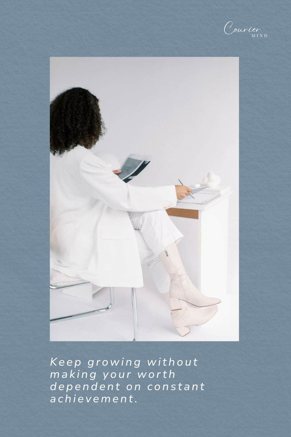 A woman dressed in white is seen from behind while working at her desk.