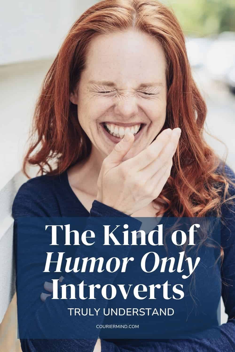 A woman with long hair laughs outdoors, leaning slightly forward with one hand raised near her face.