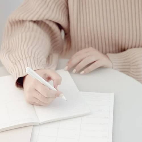 Woman writing in journal.